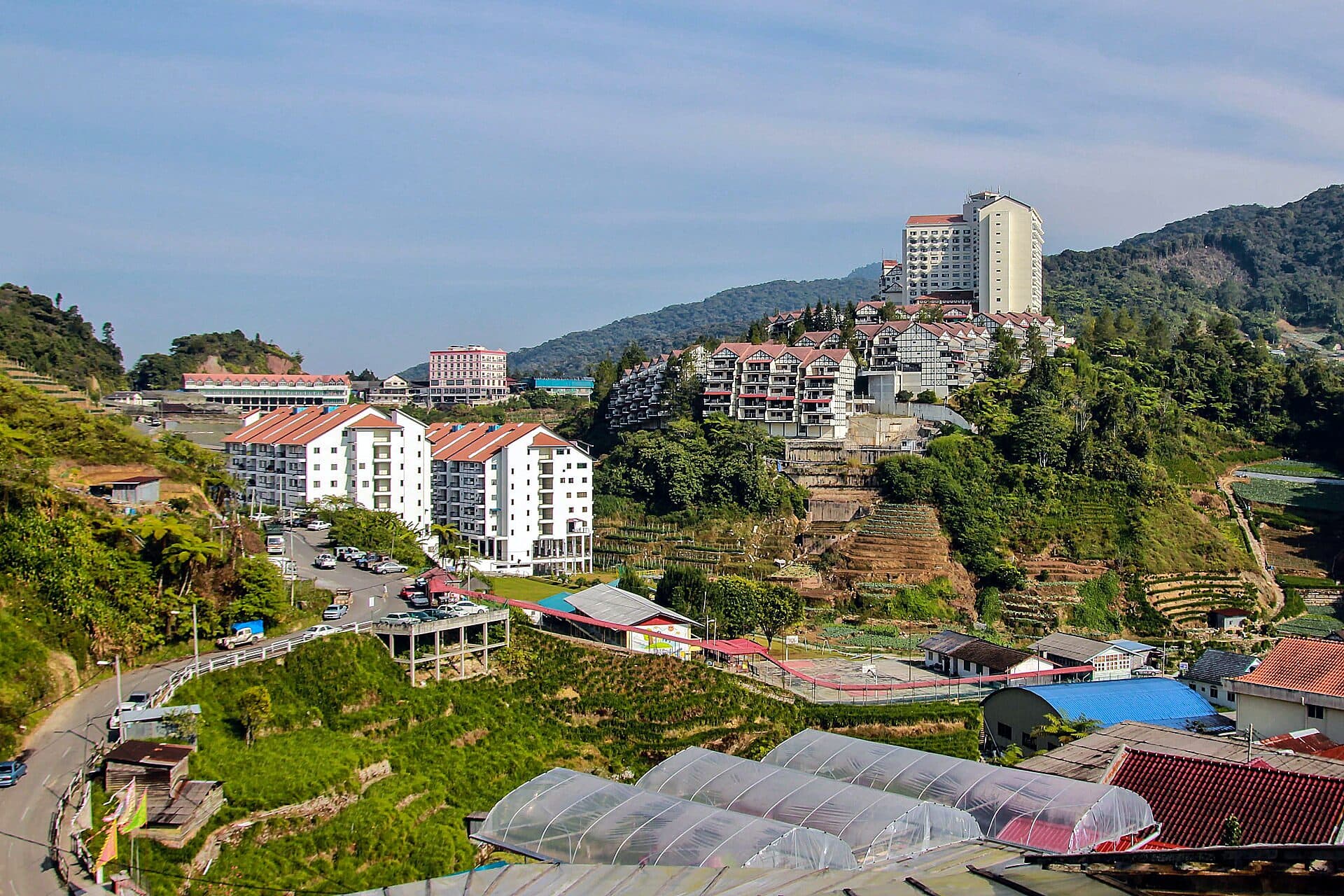 The hillside town of Brinchang, Cameron Highlands — apartment blocks and a hotel above terraced farms and greenhouses